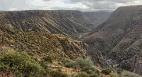 IMG 5719-HDR(3) stitch  The east-westcanyon ahead is the Perry Tank Canyon, cut by a stream that flows into the Agua Fria River.  The AFRiver has cut a 1000 ft deep, north (left)-south (right) canyon through (lower right quadrant of this photo) the National Monument.  Both rims of Perry Tank Cayon are homes to ruins of Pueblo Indians (Perry Tank Canyon Ruins on the north rim and Rattlesnake Perry Tank Canyon Ruins on the south rim, both of which we plan to visit n the future.